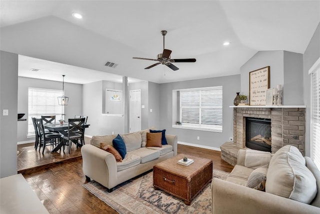 704 Firethorn Ln, Round Rock, TX 78664 - living room featuring vaulted ceiling, wood finished floors, a ceiling fan, baseboards, and a brick fireplace