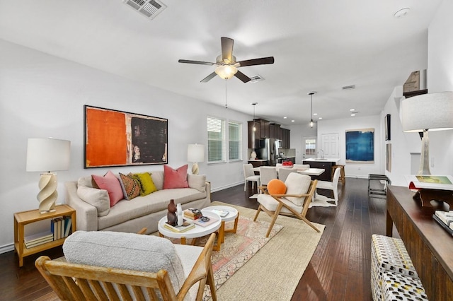 5400 Golden Canary Ln Unit 49, Austin, TX 78723 - living area with dark wood finished floors, baseboards, visible vents, and a ceiling fan