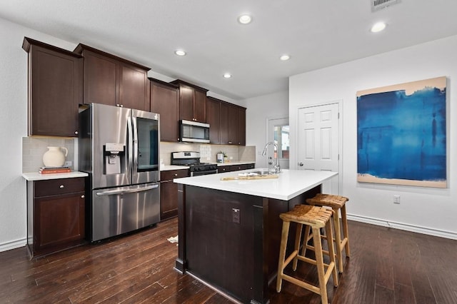 5400 Golden Canary Ln Unit 49, Austin, TX 78723 - kitchen with backsplash, light countertops, stainless steel appliances, and dark wood-type flooring