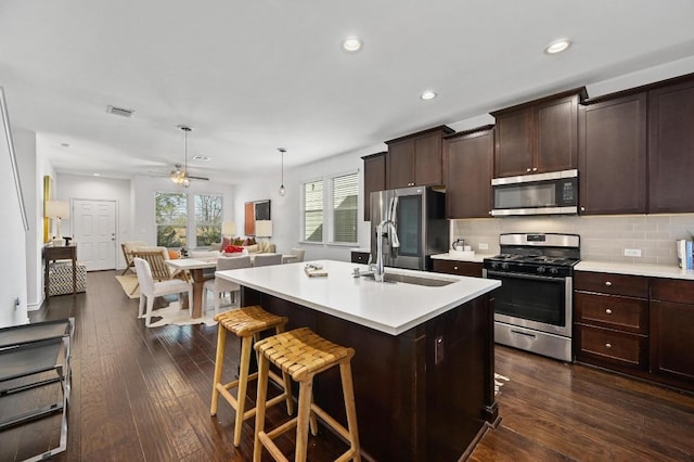 5400 Golden Canary Ln Unit 49, Austin, TX 78723 - kitchen featuring open floor plan, light countertops, a sink, dark wood-style floors, and appliances with stainless steel finishes