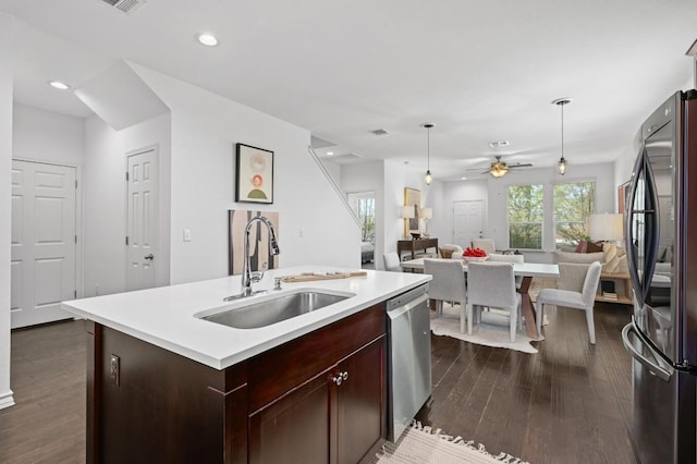 5400 Golden Canary Ln Unit 49, Austin, TX 78723 - kitchen with light countertops, a sink, appliances with stainless steel finishes, open floor plan, and dark wood-type flooring