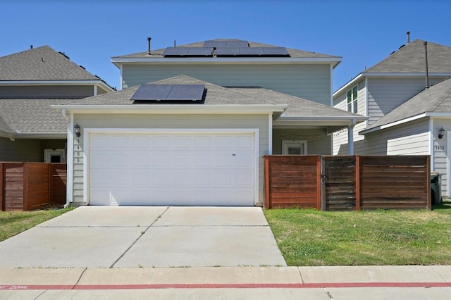 5400 Golden Canary Ln Unit 49, Austin, TX 78723 - view of front of house with concrete driveway, fence, an attached garage, a gate, and roof mounted solar panels