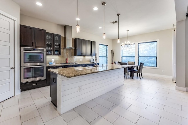 15089 Joseph Dr, Austin, TX 78734 - kitchen with appliances with stainless steel finishes, wall chimney exhaust hood, tasteful backsplash, dark stone counters, and glass insert cabinets