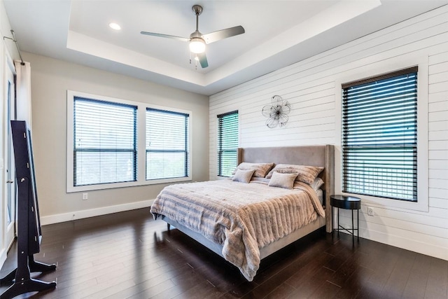15089 Joseph Dr, Austin, TX 78734 - bedroom with a raised ceiling, dark wood-style flooring, wooden walls, and ceiling fan