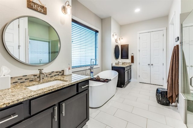 15089 Joseph Dr, Austin, TX 78734 - full bath featuring two vanities, a freestanding bath, tile patterned floors, recessed lighting, and a shower with door