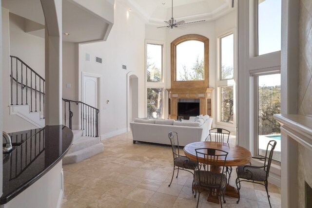 19801 Angel Bay Dr, Spicewood, TX 78669 - dining area with a towering ceiling, arched walkways, stairs, ceiling fan, and baseboards