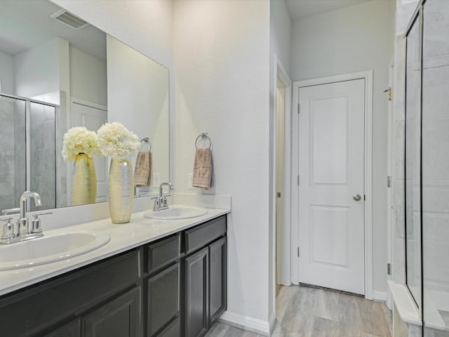 218 Pearland St, Hutto, TX 78634 - full bath with a shower stall, wood finished floors, and double vanity