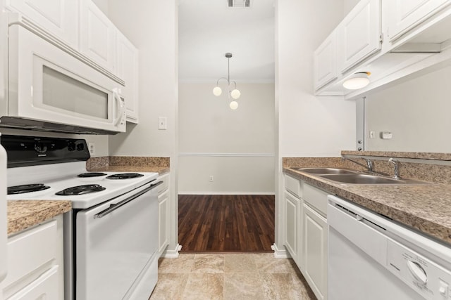 kitchen featuring white appliances, crown molding, a sink, and white cabinets