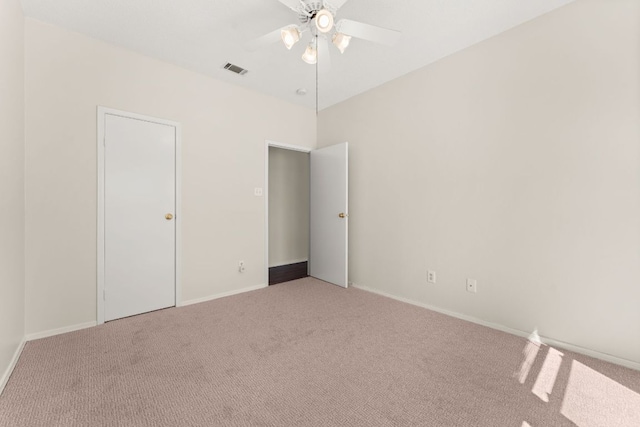 carpeted spare room featuring a ceiling fan, baseboards, and visible vents