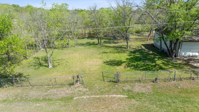405 E Browning St, Manor, TX 78653 - view of yard featuring a garage and a wooded view