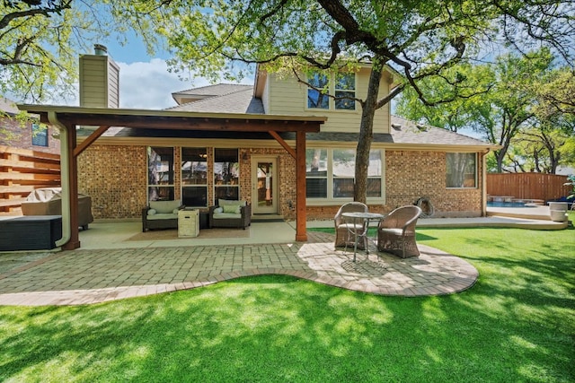 back of property with a patio area, an outdoor living space, a chimney, brick siding, and a shingled roof