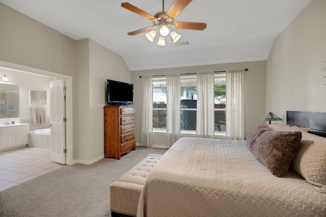 bedroom featuring lofted ceiling, light colored carpet, baseboards, ensuite bathroom, and a ceiling fan