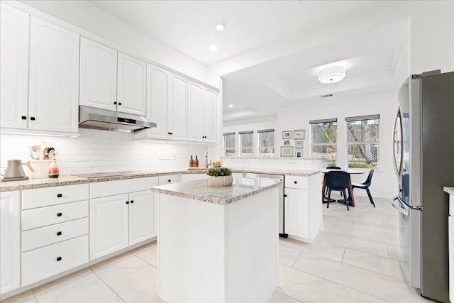 kitchen with under cabinet range hood, appliances with stainless steel finishes, decorative backsplash, white cabinets, and a peninsula