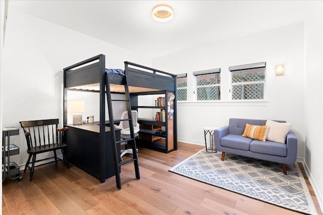bedroom featuring light wood-style floors and baseboards