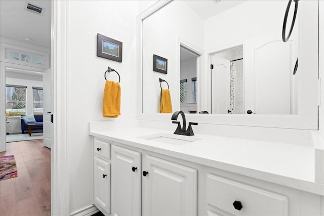 ensuite bathroom with vanity and wood finished floors