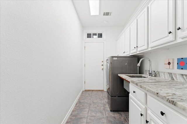 clothes washing area with cabinet space, baseboards, and washer / clothes dryer