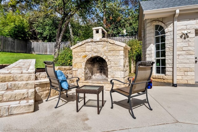 view of patio with a fenced backyard and an outdoor stone fireplace