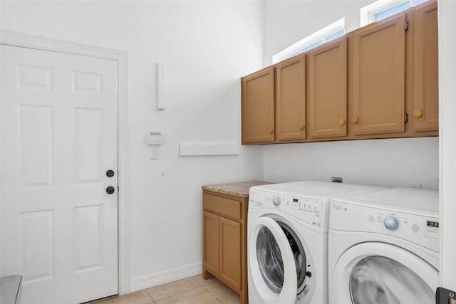 laundry room featuring independent washer and dryer, light tile patterned flooring, cabinet space, and baseboards