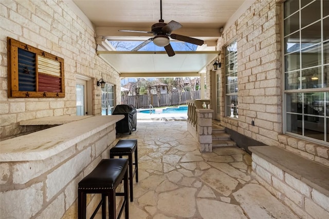 view of patio / terrace with a fenced in pool, fence, area for grilling, and a ceiling fan