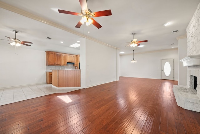 183 Augusta Dr, Wimberley, TX 78676 - unfurnished living room featuring a ceiling fan, a fireplace, crown molding, light wood-style floors, and recessed lighting