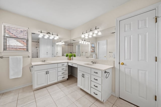 183 Augusta Dr, Wimberley, TX 78676 - bathroom featuring double vanity, a tile shower, tile patterned flooring, and baseboards