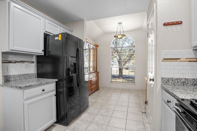 1015 Strickland Dr, Austin, TX 78748 - kitchen with black fridge, vaulted ceiling, decorative backsplash, range with electric stovetop, and light tile patterned flooring