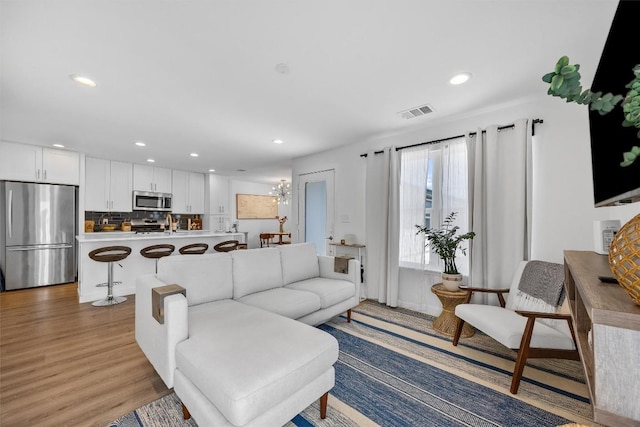 6306 Arnold Dr Unit 1, Austin, TX 78723 - living room featuring recessed lighting, light wood-type flooring, and a chandelier