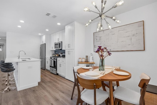 6306 Arnold Dr Unit 1, Austin, TX 78723 - dining room with a chandelier, light wood finished floors, and recessed lighting