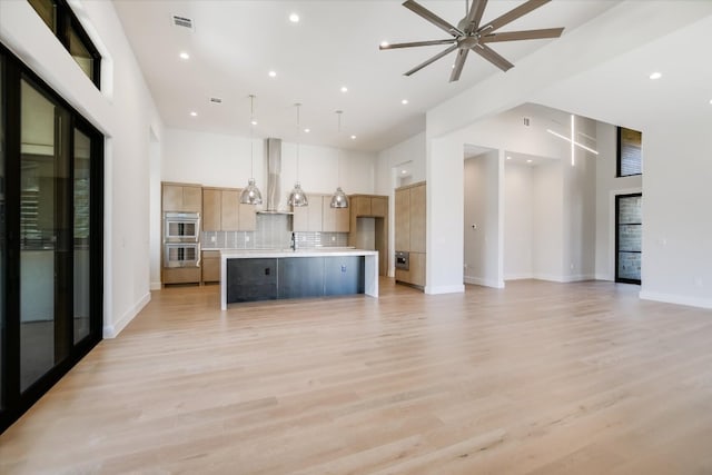 123 Azalea Loop, Horseshoe Bay, TX 78657 - unfurnished living room with a towering ceiling, recessed lighting, ceiling fan, baseboards, and light wood-style floors