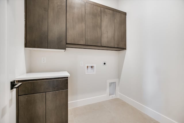 123 Azalea Loop, Horseshoe Bay, TX 78657 - washroom featuring cabinet space, hookup for an electric dryer, baseboards, hookup for a washing machine, and light tile patterned floors