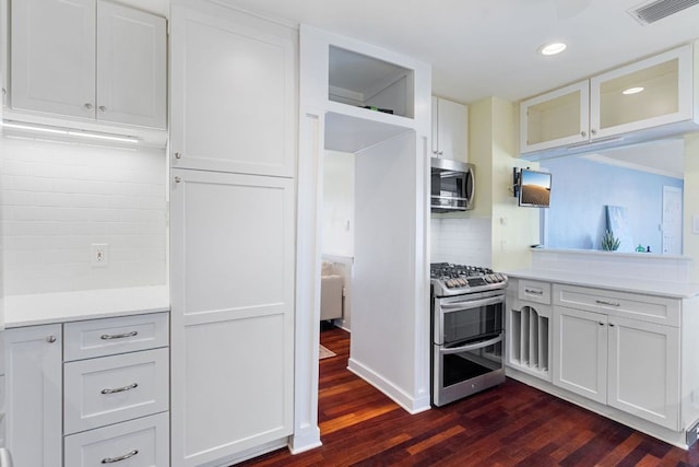 4419 Sinclair Ave, Austin, TX 78756 - kitchen featuring appliances with stainless steel finishes, dark wood-type flooring, glass insert cabinets, backsplash, and recessed lighting