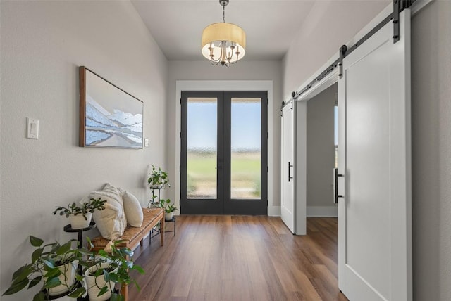 200 County Road 246, Florence, TX 76527 - entrance foyer with french doors, a barn door, wood finished floors, a chandelier, and baseboards