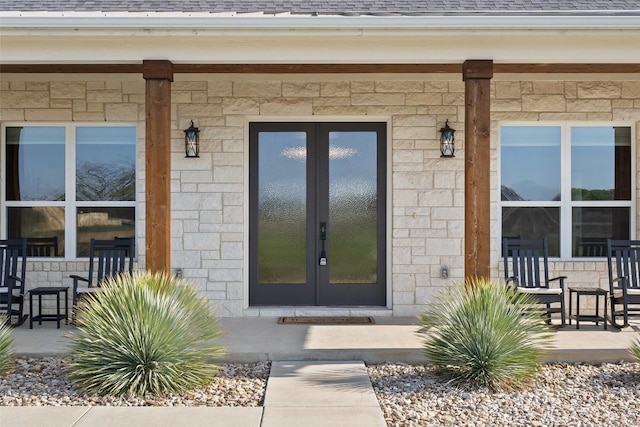 200 County Road 246, Florence, TX 76527 - view of exterior entry with french doors, stone siding, and roof with shingles
