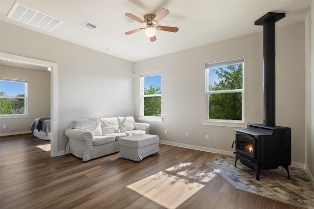 200 County Road 246, Florence, TX 76527 - living room with a wood stove, baseboards, wood finished floors, and a ceiling fan