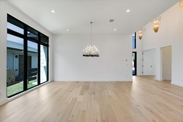 317 Azalea Ct, Horseshoe Bay, TX 78657 - unfurnished room with a chandelier, light wood-style floors, plenty of natural light, a high ceiling, and recessed lighting