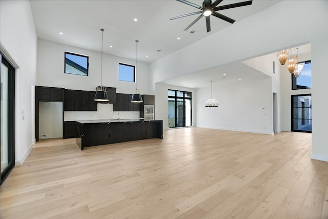 317 Azalea Ct, Horseshoe Bay, TX 78657 - kitchen featuring a towering ceiling, open floor plan, a chandelier, and recessed lighting