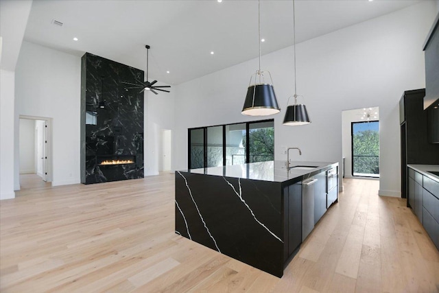 317 Azalea Ct, Horseshoe Bay, TX 78657 - kitchen featuring a towering ceiling, a sink, modern cabinets, plenty of natural light, and dark cabinets