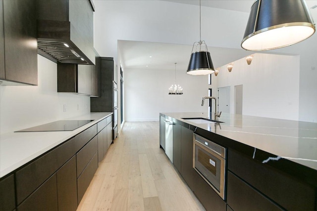 317 Azalea Ct, Horseshoe Bay, TX 78657 - kitchen featuring a sink, black electric cooktop, wall chimney exhaust hood, light wood-type flooring, and a chandelier