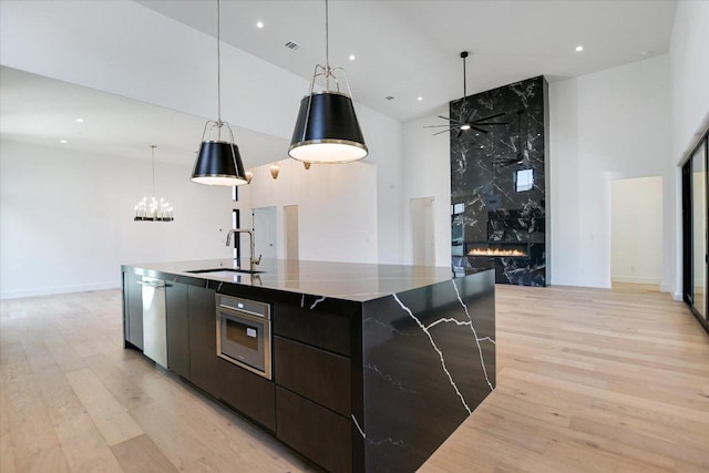 317 Azalea Ct, Horseshoe Bay, TX 78657 - kitchen with high vaulted ceiling, a sink, modern cabinets, light wood finished floors, and stainless steel appliances