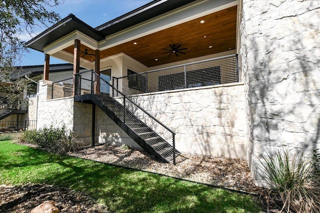 317 Azalea Ct, Horseshoe Bay, TX 78657 - rear view of property featuring a ceiling fan, stairway, stone siding, and fence