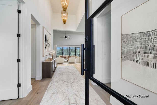 317 Azalea Ct, Horseshoe Bay, TX 78657 - hall featuring light wood finished floors, a chandelier, and a high ceiling