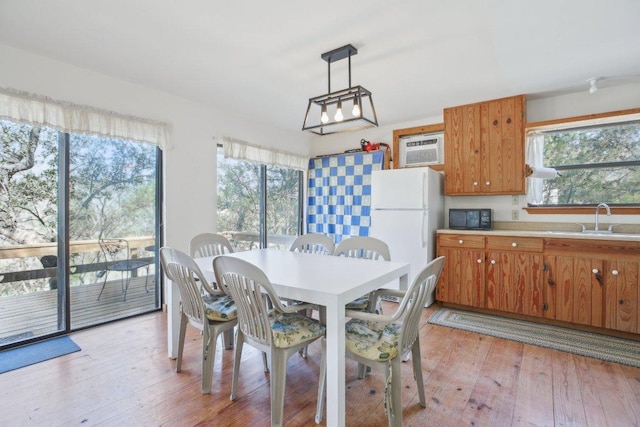 520 River Rapids Rd, Wimberley, TX 78676 - dining space with healthy amount of natural light, light wood-type flooring, and an AC wall unit