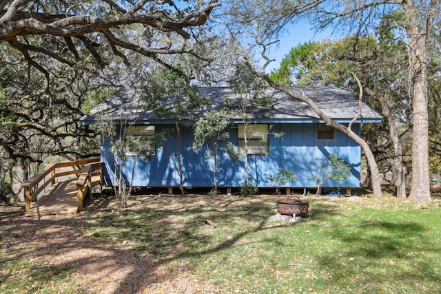 520 River Rapids Rd, Wimberley, TX 78676 - view of side of home featuring an outdoor fire pit, a shingled roof, and a lawn