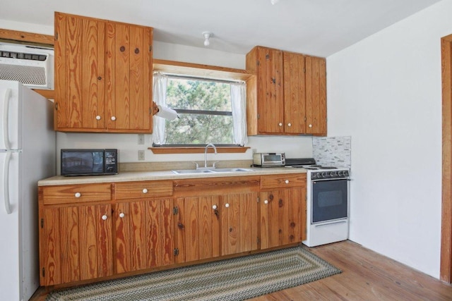 520 River Rapids Rd, Wimberley, TX 78676 - kitchen featuring white appliances, wood finished floors, light countertops, and brown cabinetry