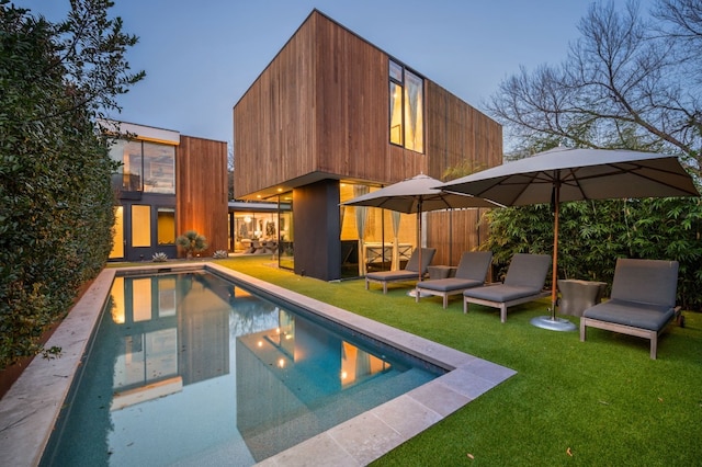 exterior space featuring an outdoor pool and a yard