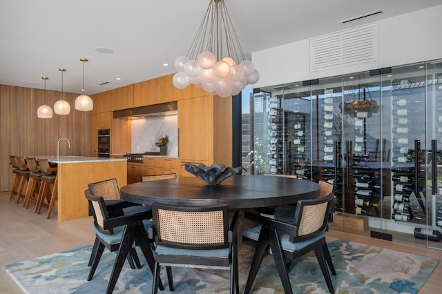 701 W Elizabeth St, Austin, TX 78704 - dining space featuring wood walls, light wood-style floors, and a chandelier