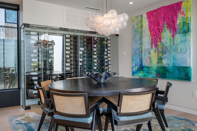 wine cellar with wood finished floors, recessed lighting, and a chandelier