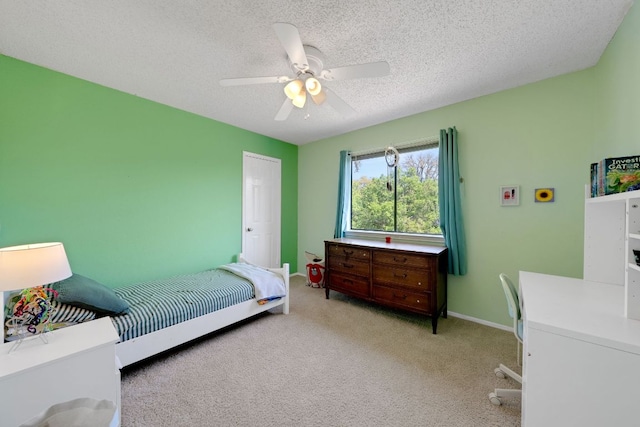carpeted bedroom with a ceiling fan, baseboards, and a textured ceiling