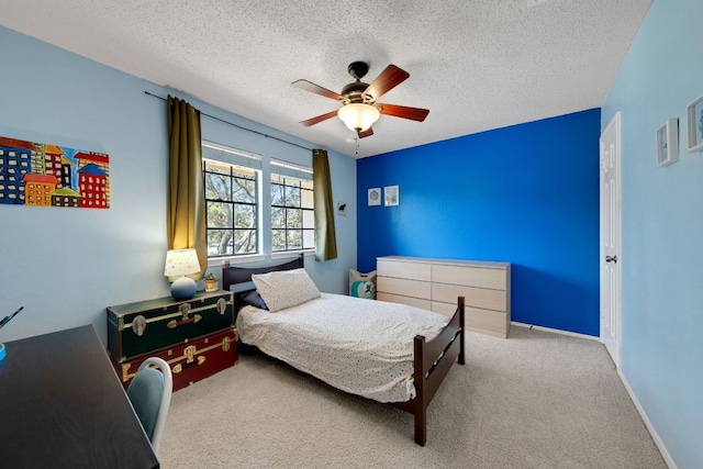 carpeted bedroom featuring baseboards, a textured ceiling, and a ceiling fan