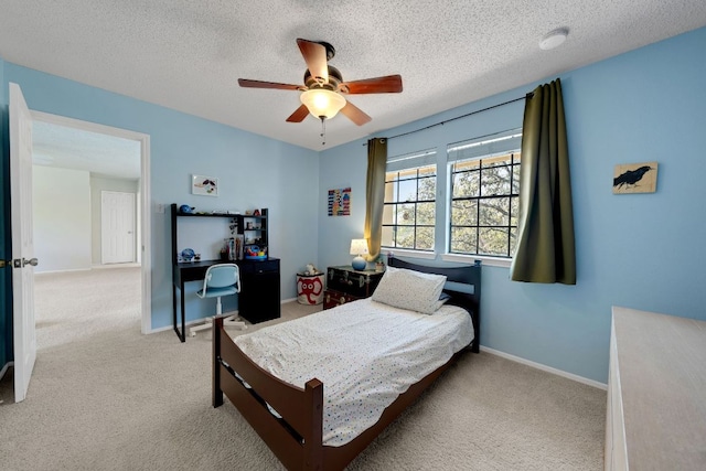 carpeted bedroom featuring baseboards, ceiling fan, and a textured ceiling